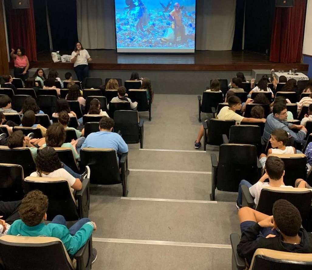 Palestra de educação ambiental para estudantes em um auditório escolar